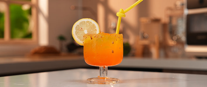 Golden Sunset cocktail with graham cracker rim and lemon garnish for drink prep guide.