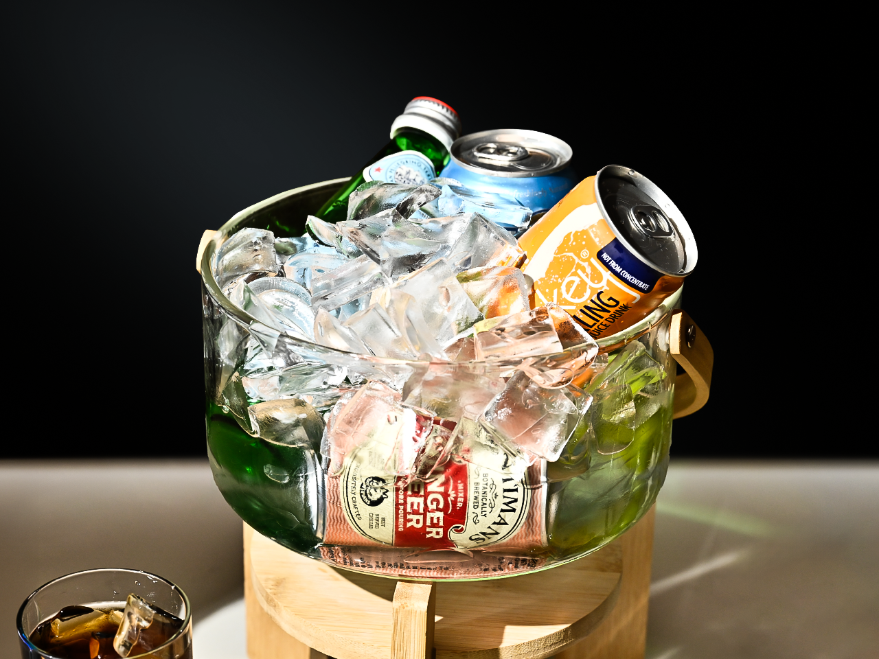 Canned drinks and bottled water stay chilled in a glass bowl filled with ice from an ice maker.